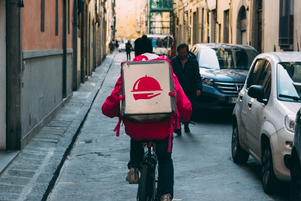 Delivery courier riding a bicycle with a food delivery bag